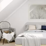 Chambre mansardée lumineuse avec un lit, une chaise et un climatiseur mural